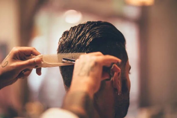 Φωτογραφία Close-up of hairstylist's hands cutting strand, wundervisuals